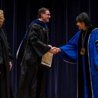 Provost, faculty shaking hands with President